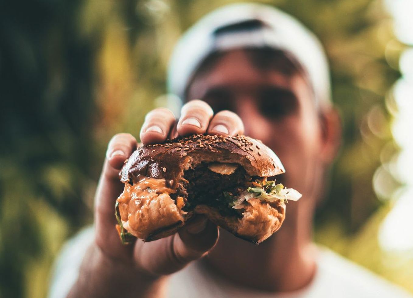 Man showing half eaten burger